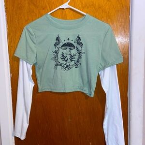 A vibrant green top with white sleeves, adorned with an adorable mushroom logo